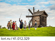Участники исторического клуба "Гардемарин" (г. Кондопога) на фоне мельницы в музее Кижи. Летний облачный день. Редакционное фото, фотограф Сергей Цепек / Фотобанк Лори