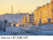 Улица в северном городе в Арктике. Зимний городской пейзаж. Машины едут по заснеженной улице. Здания на закате. Телекоммуникационные башни на горе. Город Анадырь, Чукотка, Россия. Стоковое фото, фотограф Андрей Степанов / Фотобанк Лори