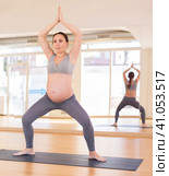 Pregnant woman is engaged in yoga. Goddess Pose or utkata konasana. Стоковое фото, фотограф Татьяна Яцевич / Фотобанк Лори