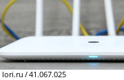 Белый беспроводной Wi-Fi маршрутизатор или роутер и кабели на белом столе. Съёмка в движении. Стоковое видео, видеограф Евгений Ковальский / Фотобанк Лори