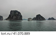 Quaint islands with steep slopes hide in the fog. Tourist ships sail in the calm waters of the bay. Halong Bay. Vietnam. Стоковое фото, фотограф Вера Ивановна Кубарева / Фотобанк Лори