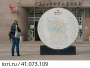 Moscow, Russia - May 15, 2020: Young woman with backpack talking on mobile phone. Entrance of the Barrikadnaya subway station during coronavirus pandemic time. Almost no people. Редакционное фото, фотограф YuryKara / Фотобанк Лори