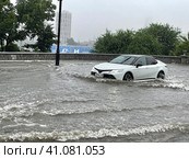 Автомобиль едет по подтопленной улице Набережная в городе Владивосток в период циклона (2023 год). Редакционное фото, фотограф Овчинникова Ирина / Фотобанк Лори
