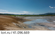 Thermal springs in the crater of the extinct volcano Uzon. Blue streams and puddles are visible. There are sulphurous deposits on the soil. A picturesque mountain range against the azure sky.Kamchatka. Стоковое фото, фотограф Вера Ивановна Кубарева / Фотобанк Лори