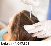 Close-up of head of female client receiving injections during medical procedure, hands of professional beautician in rubber gloves with syringe. Стоковое фото, фотограф Яков Филимонов / Фотобанк Лори