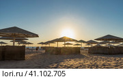 Morning on the Red Sea beach. The rays of the sun illuminate the lattice umbrellas and wicker fences. Blue sky. Light and shadows on the undulating sand. Egypt. Safaga. Стоковое фото, фотограф Вера Ивановна Кубарева / Фотобанк Лори
