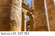 The columns of the hypostyle hall in the Karnak Temple of Luxor against the blue sky. Hieroglyphs and carvings are visible. Close-up. Egypt (2021 год). Стоковое фото, фотограф Вера Ивановна Кубарева / Фотобанк Лори