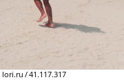 A young swarthy woman in a bikini and a light red dress walks barefoot on a sandy beach in the surf water. Стоковое видео, видеограф Aleksey Kidisyuk / Фотобанк Лори