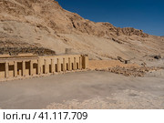 Fragment of the funerary temple of the queen-Pharaoh Hatshepsut on the background of a steep cliff. An ancient colonnade and a brick wall are visible. Clear blue sky. Egypt. Luxor (2021 год). Стоковое фото, фотограф Вера Ивановна Кубарева / Фотобанк Лори
