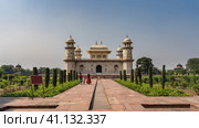 The ancient mausoleum of Itmad-Ud-Daula. The building is made of white marble with minarets. Arched openings, barred windows, ornaments, inlays of precious stones. People are walking along the path. (2022 год). Стоковое фото, фотограф Вера Ивановна Кубарева / Фотобанк Лори