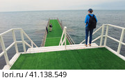 Women walk along the pier stretching into the Black Sea. Стоковое видео, видеограф Станислав Типляшин / Фотобанк Лори