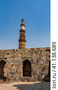 The ancient temple complex of Qutub Minar. Weathered sandstone brick walls with arches. The world's tallest minaret against the blue sky. India. Delhi. (2022 год). Стоковое фото, фотограф Вера Ивановна Кубарева / Фотобанк Лори