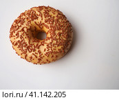 A doughnut or donut. A type of leavened fried dough. Sweet snack that can be homemade or purchased in bakeries, supermarkets, food stalls. Delicious pie with light icing on a white background. Стоковое фото, фотограф Юлия Петровская / Фотобанк Лори