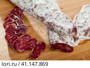 Slicing delicious Spanish smoked sausage fuete. Стоковое фото, фотограф Яков Филимонов / Фотобанк Лори