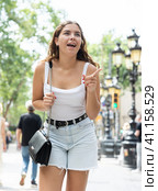 In pedestrian zone of historic European city stand suprised female tourist girl. Стоковое фото, фотограф Яков Филимонов / Фотобанк Лори