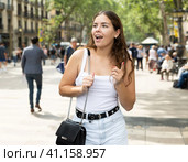 In pedestrian zone of historic European city stand suprised female tourist girl. Стоковое фото, фотограф Яков Филимонов / Фотобанк Лори