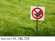 Photo of warning sign, which is meaning that walking on grass is strictly prohibited. The sign is installed in the park on the edge of the lawn area. Фотография предупреждающего знака, который означает, что ходить по траве строго запрещено. Знак установлен в парке на краю газонной зоны. Стоковое фото, фотограф Дмитрий Березнев / Фотобанк Лори