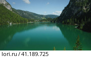 Aerial footage over lake Braies, Pragser Wildsee and mountains, in the background, on a sunny bright summer day, in Dolomites, Italy. Стоковое фото, фотограф Igor Tichonow / Фотобанк Лори