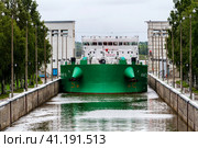 Vytegra, Russia - August 16, 2015: Cargo ship entered the White Sea-Baltic Canal Gateway. It connects the White Sea, in the Arctic Ocean, with Lake Onega, which is further connected to the Baltic Sea. Редакционное фото, фотограф VittoriaChe / Фотобанк Лори