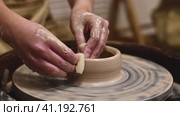 Potter girl works on potter's wheel, making ceramic pot out of clay in pottery workshop. Art and hobby concept. slow motion. Стоковое видео, видеограф Ольга Ильина / Фотобанк Лори