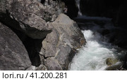 Video of popular place among tourists -  waterfall on mountain river Kyngarga. A tourist takes selfie photo on his phone near beautiful mountain stream. Summer outdoor recreation and travel. Siberia. Buryatia. Arshan resort (2023 год). Редакционное видео, видеограф Виктория Катьянова / Фотобанк Лори