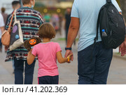 People just walking in VDNkH public park in hot summer day. A lot of people. Backs, rear view. Leisure time concept during coronavirus pandemic. Father with daughter toddler. (2021 год). Редакционное фото, фотограф YuryKara / Фотобанк Лори