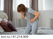 Stomach ache, symptoms of gastritis or pancreatitis, woman with abdominal pain suffering at home. Стоковое фото, фотограф Станислав Тарко / Фотобанк Лори