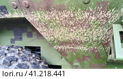 Dried mud on the sidewall of an armored war machine. Dry gray-brown clay on the khaki tank armor. Camouflage coloring of military equipment. Metal rivets, part of the wheel. Стоковое фото, фотограф Юлия Петровская / Фотобанк Лори