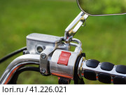 Right handle controls of classic motorcycle with chrome steering wheel and mirrors. Selective focus on start-stop button. Правая ручка управления классическим мотоциклом с хромированным рулевым колесом и зеркалами заднего вида. Выборочный фокус на кнопке "Пуск-стоп" Стоковое фото, фотограф Дмитрий Березнев / Фотобанк Лори