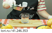 A young woman pours freshly squeezed orange juice into a transparent glass. Молодая женщина наливает свежевыжатый апельсиновый сок в прозрачный стакан. Стоковое видео, видеограф Egor Sarantstv / Фотобанк Лори