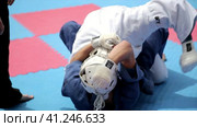 Sports wrestling. Athletes in kimonos and protective helmets on the tatami.  Спортивная борьба. Спортсмены в кимоно и защитных шлемах на татами. (2016 год). Стоковое видео, видеограф Egor Sarantstv / Фотобанк Лори