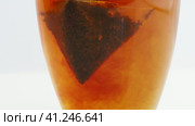 Make black tea in tea bags in a transparent cup. The texture of tea and the staining of the water. Заварите черный чай в пакетиках в прозрачной чашке. Текстура чая и окрашивание воды. Стоковое видео, видеограф Egor Sarantstv / Фотобанк Лори