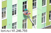 Nizhny Novgorod, Russia, School number 34 Gagarin Avenue 101 building B, 08.25.2021. A female employee of a cleaning company company washes a window on a high floor using a special lifting platform. Нижний Новгород, Россия, школа № 34, проспект Гагарина, 101, корпус В, 25.08.2021. Сотрудница клининговой компании моет окно на верхнем этаже с помощью специальной подъемной платформы. Редакционное видео, видеограф Egor Sarantstv / Фотобанк Лори
