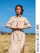 Young beautiful brunette model in a beige dress posing against the background of a mowed wheat field. Стоковое фото, фотограф Андрей Аркуша / Фотобанк Лори