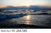 Waves with foam. Beautiful sunset. Foamy waves roll over the sandy shore. Vityazevo, Anapa, Black Sea. Tourist mecca, health resort. Colorful clouds in the evening sky. The rays reflect off the water. Стоковое фото, фотограф Юлия Петровская / Фотобанк Лори