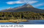 Picturesque mountains on the background of azure sky and clouds. The forest grows on the slopes. A calm blue lake in the valley. Lapataia Bay. Argentina. Tierra del Fuego National Park. Стоковое фото, фотограф Вера Ивановна Кубарева / Фотобанк Лори