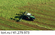 Harvesting and drying hay. The grass tedder turns freshly cut grass. Drone photo. (2023 год). Редакционное видео, видеограф Артем Лукин / Фотобанк Лори