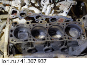The cylinder block of the four-cylinder engine. Disassembled motor vehicle for repair. Parts in engine oil. Car engine repair in the service. Стоковое фото, фотограф Леонид Еремейчук / Фотобанк Лори