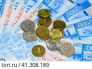 Russian banknotes and coins. A handful of coins on new Russian banknotes in denominations of 2000 and 200 rubles. Стоковое фото, фотограф Леонид Еремейчук / Фотобанк Лори