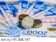 Russian banknotes and coins. A handful of coins on new Russian banknotes in denominations of 2000 and 200 rubles. Стоковое фото, фотограф Леонид Еремейчук / Фотобанк Лори