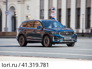 Front side view of blue crossover Geely Monjaro in motion. Geely Xingyue L suv car drive in the street (2023 год). Редакционное фото, фотограф Константин Григорьев / Фотобанк Лори