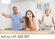 Upset adult daughter happens to reproach parents in kitchen. Стоковое фото, фотограф Яков Филимонов / Фотобанк Лори