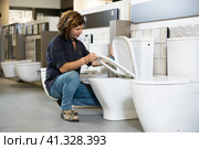 Man looking to buy new toilet in harware store. Стоковое фото, фотограф Яков Филимонов / Фотобанк Лори