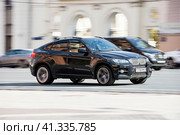 BMW X6 first generation E71, car driving in city with motion blur, front side view. Редакционное фото, фотограф Константин Григорьев / Фотобанк Лори