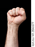 Hand clenched in fist, against a black background. Стоковое фото, фотограф Роман Сибиряков / Фотобанк Лори