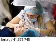 Cosmetologists perform a procedure to rejuvenate facial skin cosmetics Aravia at the festival of beauty Nevskie Berega in St. Petersburg 2012. Редакционное фото, фотограф Анна Кривицкая / Фотобанк Лори