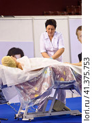 Cosmetologists perform a procedure to rejuvenate facial skin cosmetics Aravia at the festival of beauty Nevskie Berega in St. Petersburg 2012. Редакционное фото, фотограф Анна Кривицкая / Фотобанк Лори