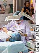 Cosmetologists perform a procedure to rejuvenate facial skin cosmetics Aravia at the festival of beauty Nevskie Berega in St. Petersburg 2012. Редакционное фото, фотограф Анна Кривицкая / Фотобанк Лори