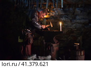 Russia, St. Petersburg 28,12,2016 Blacksmith in a medieval forge at the medieval festival "Days of History" (2015 год). Редакционное фото, фотограф Анна Кривицкая / Фотобанк Лори