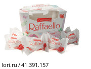 A box of Raffaello spring collection with candy scattered in front of it in a package isolated on a white background (2021 год). Редакционное фото, фотограф Воловодов Владимир / Фотобанк Лори